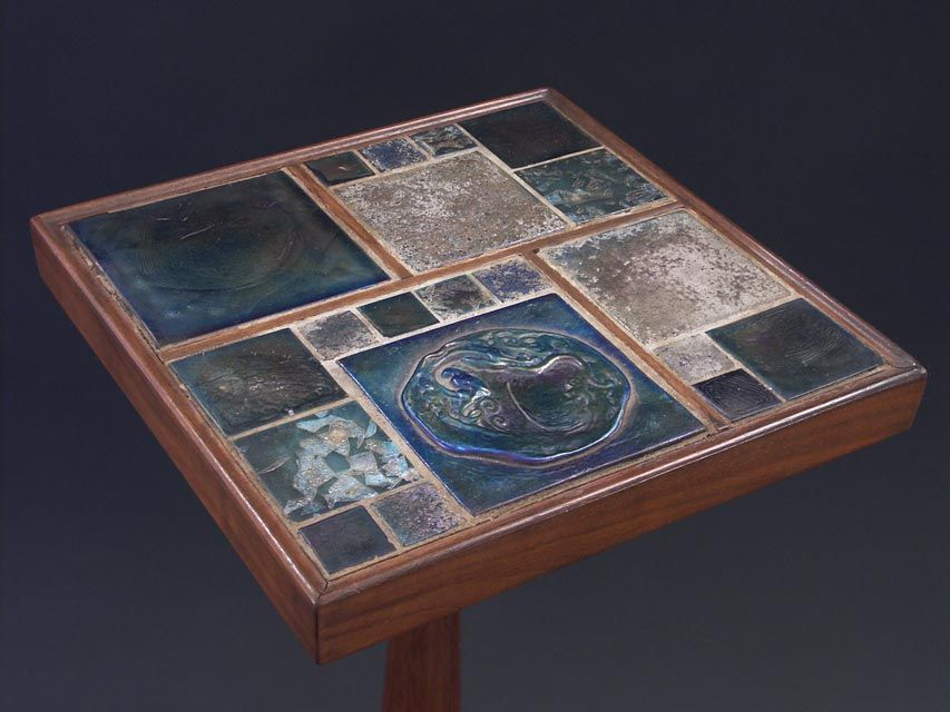 According to legend, Edward Wormley purchased a large collection of Tiffany glass tiles at auction inthe early 1950's; The tiles were utilized in a variety of ways on several table designs, often sparingly. This diminutive side tabletakes the idea