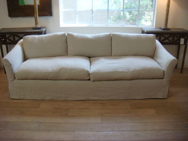 Long, comfortable sofa with down filled cushions slip covered in washed Belgian linen. Frame is old, upholstered in new muslin with light, natural colored linen.