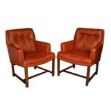 Pair of mahogany and brick red leather arm chairs by Dunbar