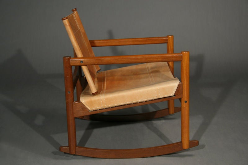 Simple rocking chair with sling seat and back of light brown leather with pale stitching. Seat depth is 19