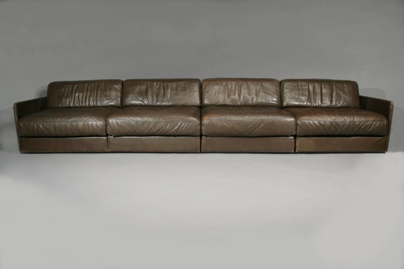 A sectional sofa in dark brown leather that folds out to form a bed by De Sede. Seat depth is 26