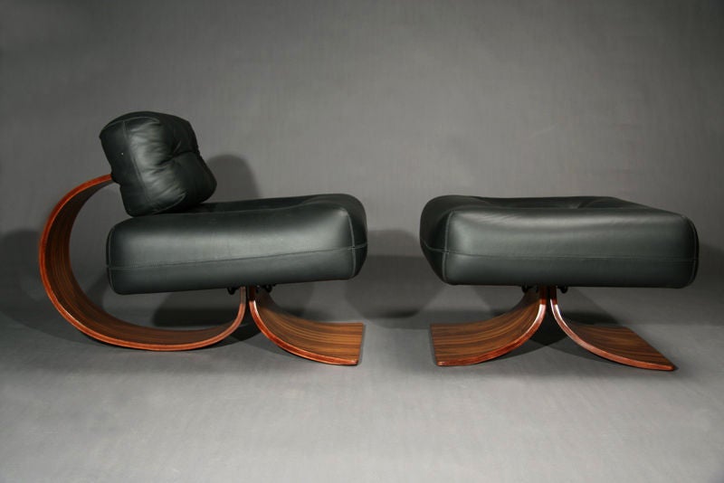 Black leather and rosewood lounge chair and ottoman designed by Brazil's Oscar Niemeyer.  This is a very rare version of this design produced by Tendo Brasileira circa 1980 and should not be confused with the recent production of Niemeyer