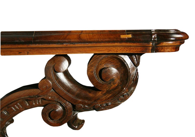 A rosewood console or shelf with intricately carved scroll supports that mounts on the wall at any height desired.

 