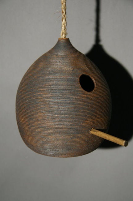 A glazed stoneware bird house with wooden support pole.  Several available; dimensions are variable