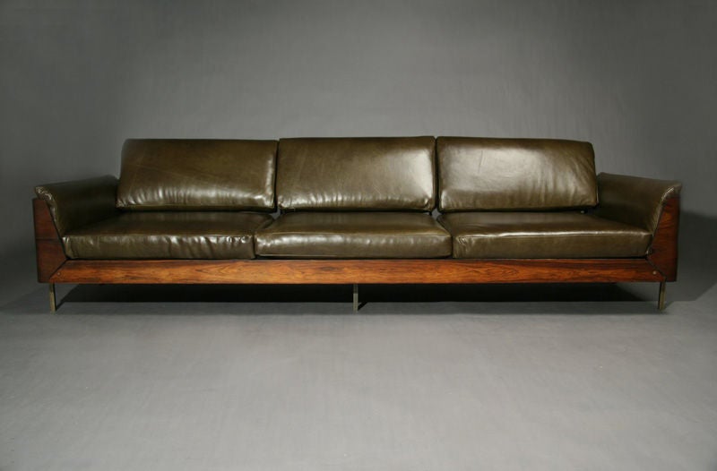 A rosewood frame sofa with skeleton back and bronze legs upholstered in olive green leather by Jorge Zalszupin.