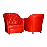A pair of button-tufted red leather chairs by Ward Bennett