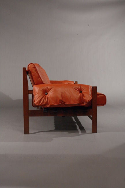 Rosewood A rosewood and red leather sofa with black pigskin straps