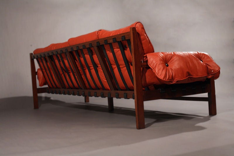 A rosewood and red leather sofa with black pigskin straps 1