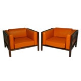 Pair of rosewood and orange leather arm chairs