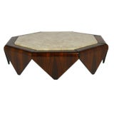A large octagonal rosewood and travertine coffee table