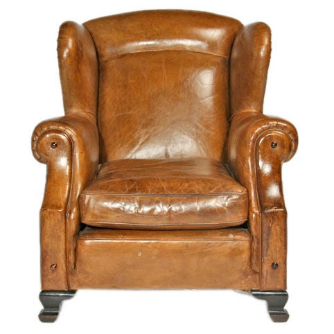 A Brazilian take on the leather wingback chair with rivets, piping, and other nice design elements.