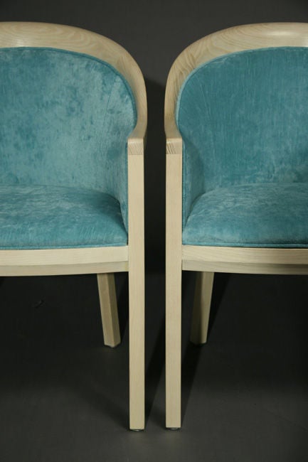 A pair of bleached oak arm chairs with curved backs upholstered in a light blue fabric. We have another pair that has not been reupholstered yet; the COM price for that pair is $3,000.