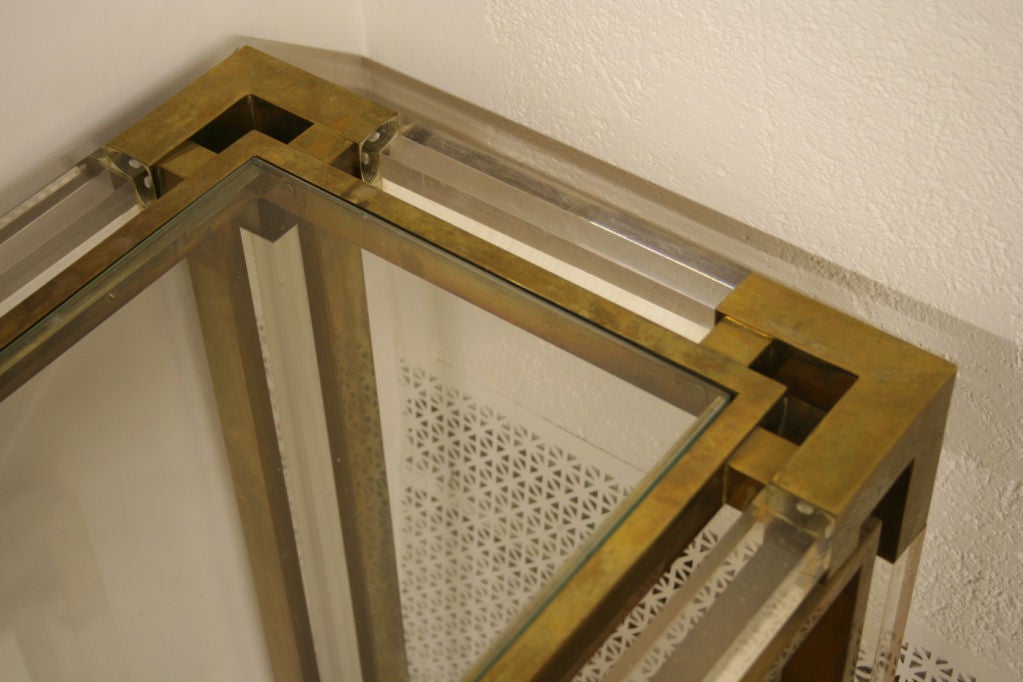 Console and mirror in lucite and patinated brass. The mirror measures 32 inches X 40 inches and there are two available.