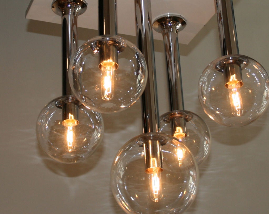 Ceiling Fixture with five hand blown globes attached to a chrome stem four smaller and shorter surround the center that is slightly longer and larger