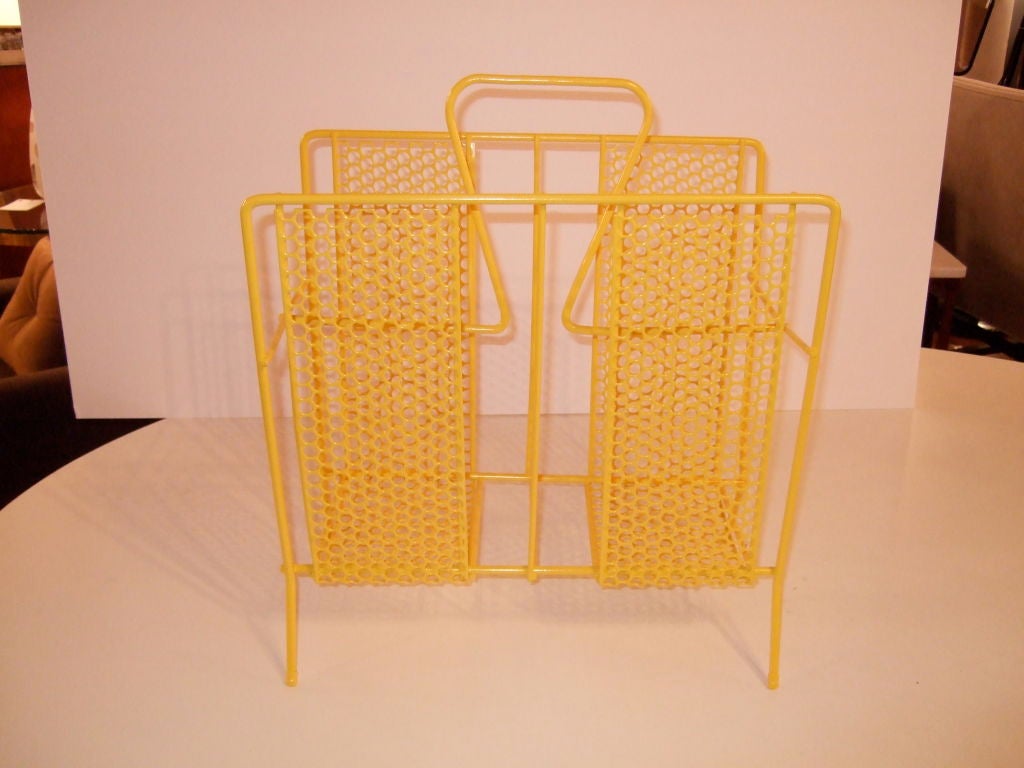 Bright yellow powder coated magazine rack.  This fun magazine rack keeps magazines elevated off the floor.  Made of steel with a durable powder coated finish perfect for the bathroom humidity.  The feet are tipped with rubber feet.<br />
<br