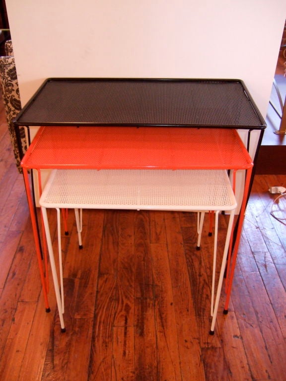 We love everything about this fun trio of nesting tables, poised on sinewy steel legs and powder coated in black, red orange, and white.