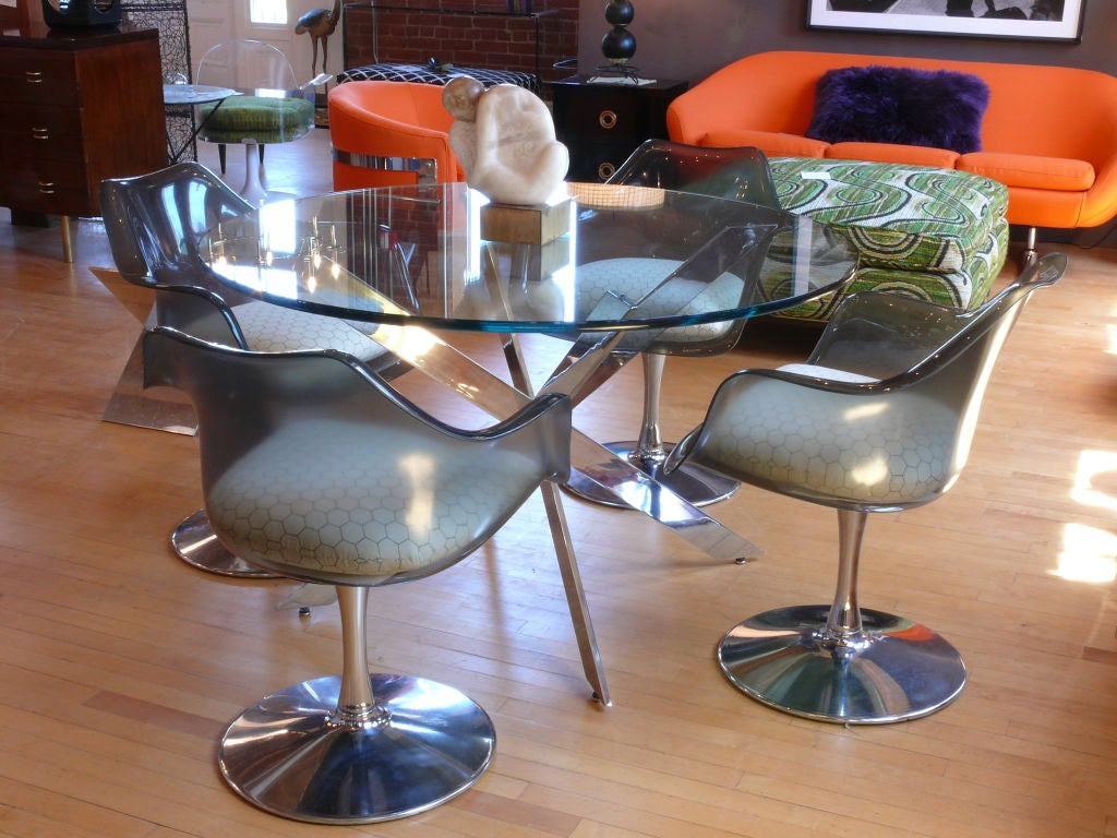 Four amazing smoked Lucite chairs.  The chairs have custom made chicken wire cushions. Polished chrome tulip bases.  They are simply stunning!