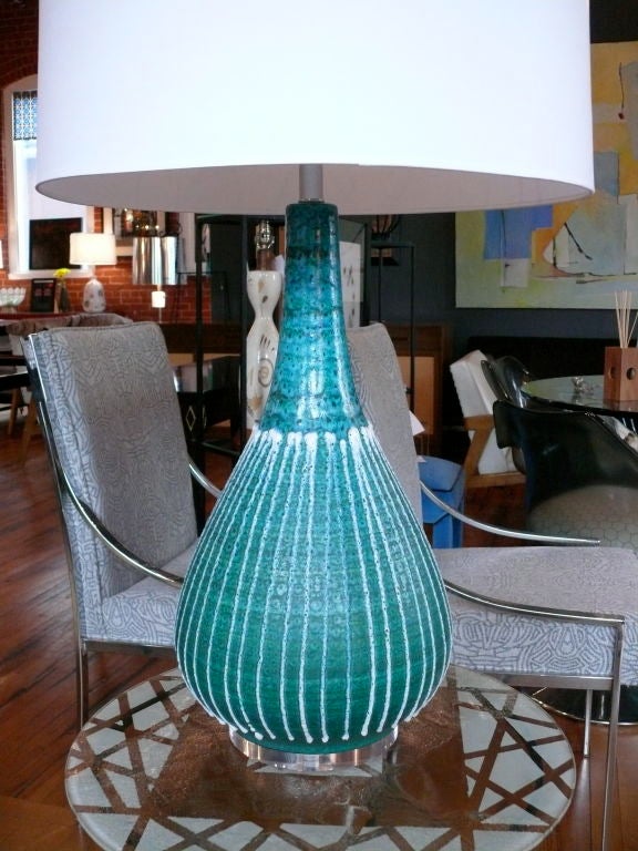 Add a splash of color with our large, turquoise ceramic lamp.  Prized for its shapely silhouette and vibrant color, our lamp casts personality and style in the bedroom or living room!  Hand drawn  white stripes and subtle bubbles and striations make