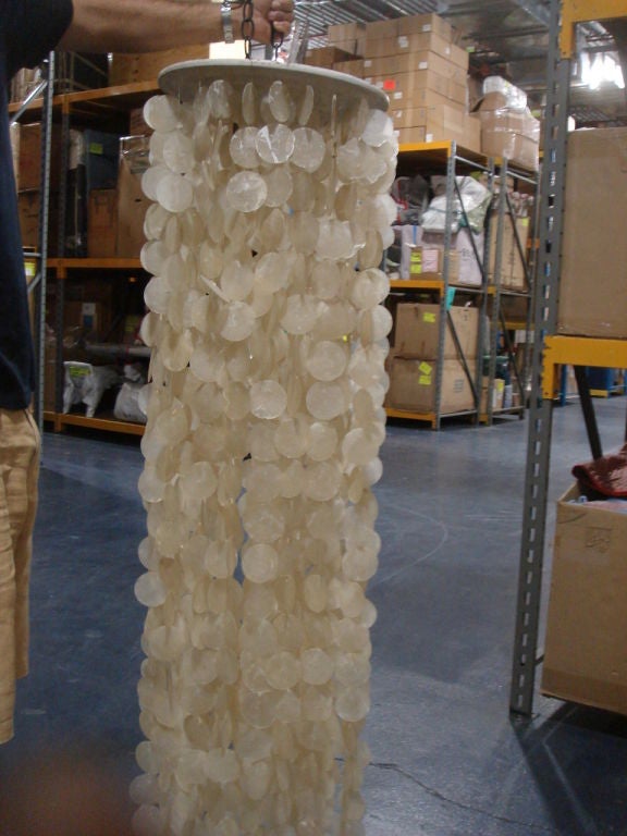 A long Capiz Shell light in a gold tone. Wooden disc supports the string of shell disks.