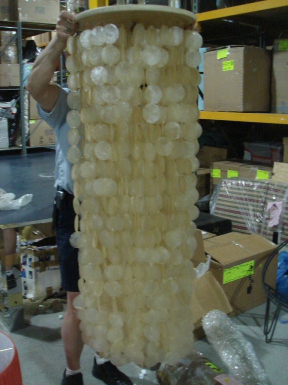A large Capiz shell hanging light suspended by a wooden disk. Additional Capiz valance included which is optional to use.