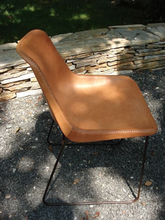 A contoured leather clad chair with baseball stitching along the seams, on a metal frame.<br />
<br />
Seat height is 18