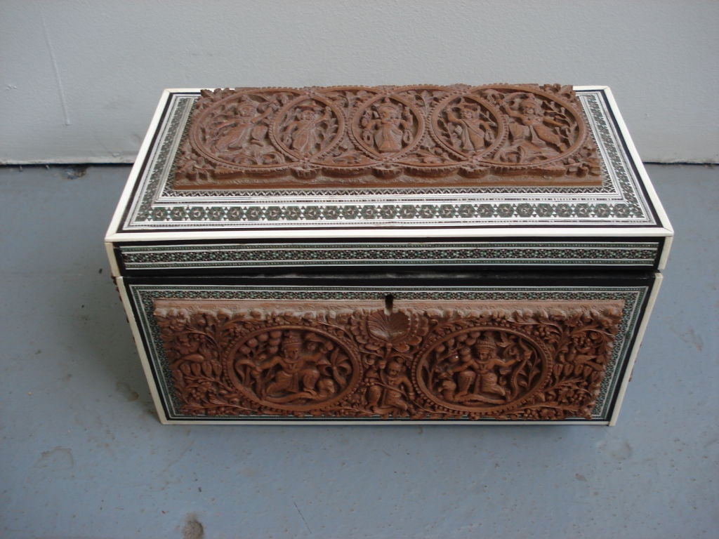 A fine Anglo-Indian tea caddy with panels on each side deeply carved and inlaid ivory and pewter decoration at the border with two internal compartments with two lids that are carved in ebony.