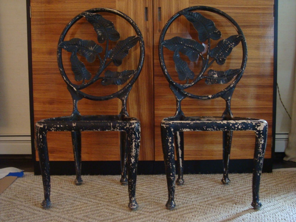 A pair of unique metal chairs with a classic banana leafs in the oval of the back splat. Similar designs were created for the Fontainebleau Hotel in Miami Beach for architect Morris Lapidus circa 1950. <br />
Seat measures 15