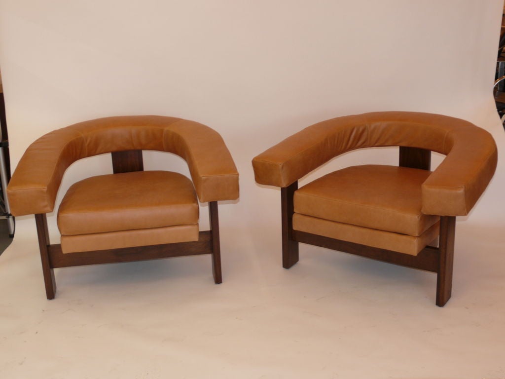 Newly produced and designed by Orange, walnut 3 legged chairs with beautiful carmel leather upholstery.