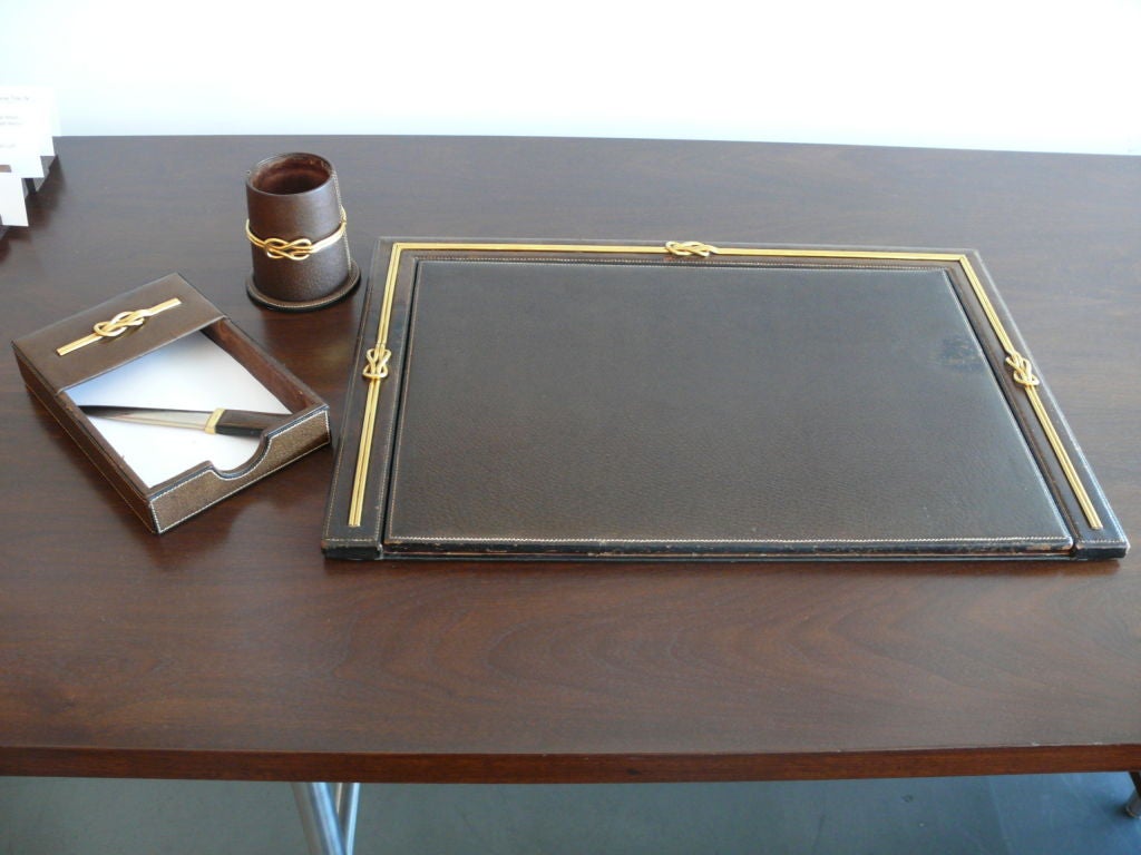 Beautiful brown leather Gucci desk set including; Blotter, pencil holder, and paper tray with signature Gucci logo and thick brass detailing. Envelope opener not available. Priced accordingly.