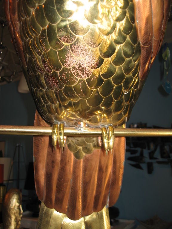 Massively scaled parrot on perch designed by Sergio Bustamante, dating to the 1970's.  Realized in brass and copper with eyes of glass, this sculpture has very detailed feathering, and retains it's original finish and patina. 24 HOUR HOLD ONLY