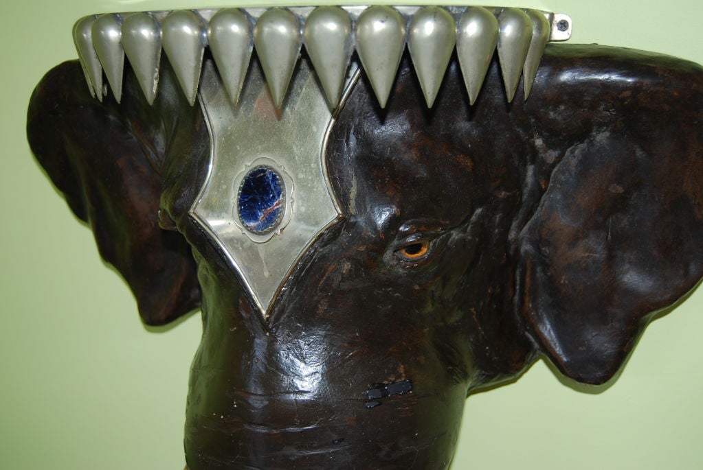 Wonderful 1960's Anthony Redmile wall hung elephant console/pedestal with glass eyes.Head dress is adorned with silver plate over brass with lapis stone inset.Perfect for foyer or as a pedestal to display an object.