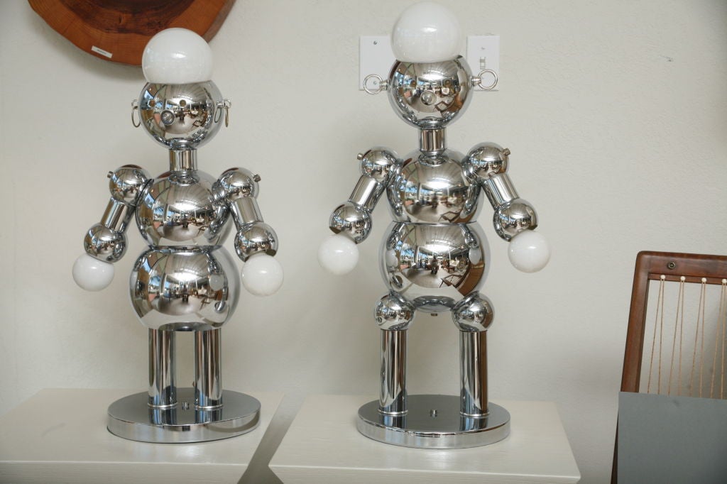 A double delight finding this male and female chrome robot couple by Torino. Whimsical chrome lamps have 3-way nose switches that turn on either head and eyes only, hands only, or head and hands  together. Perfect for a child's room or  the Sci-Fi