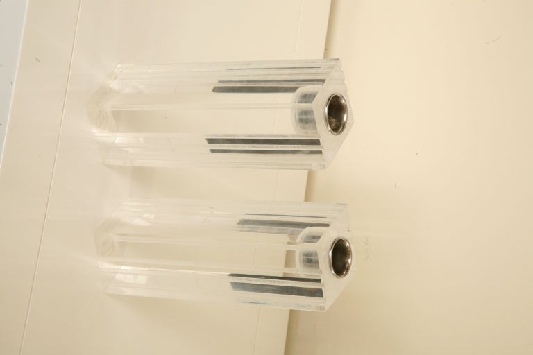 Pair of lucite candle sticks with engraved ridges on two sides. Chrome holders are removable to clean with ease.