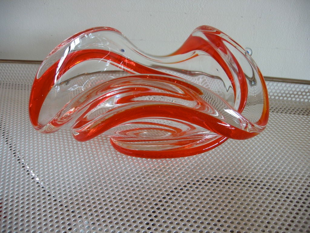 Glass dish with three large scalloped edges and red/orange swirls running through it. Signed.