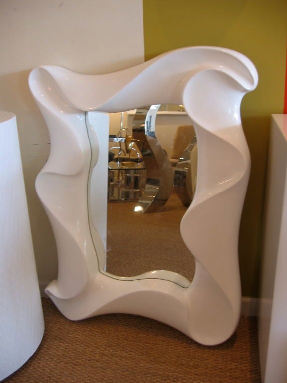 High gloss white lacquered mirror with sculptural folded appearance. A very fluid mirror with a swirl feel and signed in the lower corner. Can be hung vertically and horizontally.
