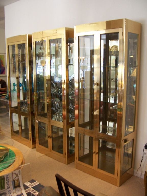 Only 4 available, Priced and sold individually.

An incredible hard to come by set of well crafted brass vitrines by Mastercraft (metal label). These vitrines are illuminated on dimmers - four doors each (two large on top and two small at the