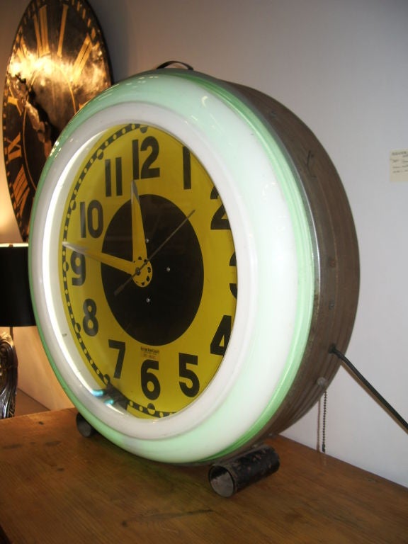 Yellow and black face neon clock with green and white neon band outer rim which lights up. Metal body and tubular feet.All original and working. Labeled electric neon clock company, Cleveland Ohio. Great looking
