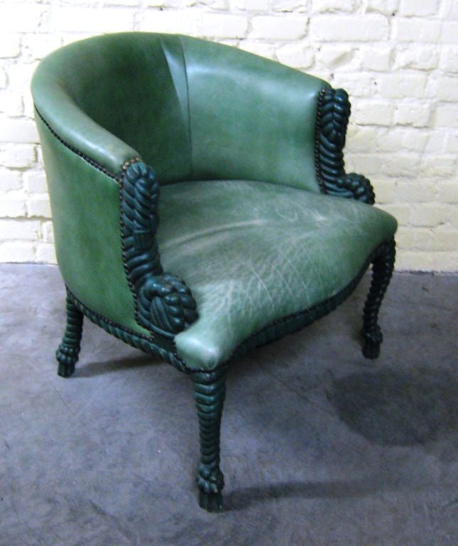 Unusual green leather chair. The frame has interesting decorative details as do the legs. Nail head accents throughout.