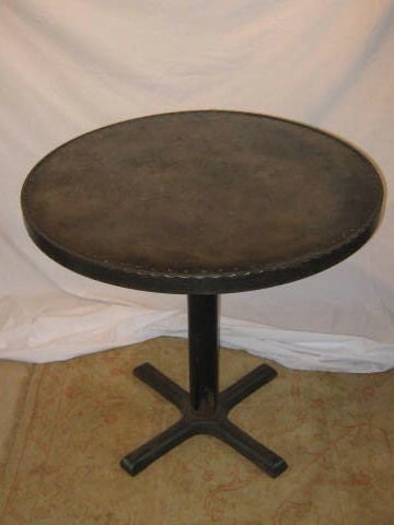 Vintage table base with a contemporary industral iron top. Decorative scroll design around the table rim.