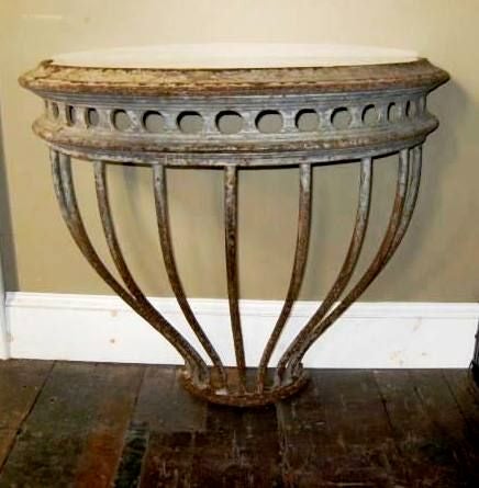 This 19thC open iron grillwork base has been redefined into a marble top demilune table. There is a grey/green patina to the iron.