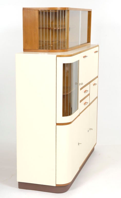 painted solid beech, chrome and orange resin fixtures, original sliding glass doors; two drawers and four compartments, two with hinged-bottom drop-down doors and sic original glass containers for sugar, flour, etc., (see image); (item ID #ST66)