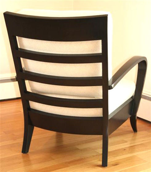 This stylish design had become an instant classic when introduced. The satin ebonized wood and original fabrics are in great condition. We have two armchairs and one ottoman. They can be purchased as a grouping or individually. The chair originally