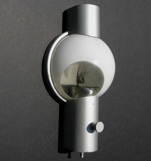 From the iconic bullet nosed 20th century Limited streamliner train comes these highly stylized wall fixtures.  The clever design allows the painted aluminum and magnified glass covers to hook onto the wall base with a simple twist of the decorative