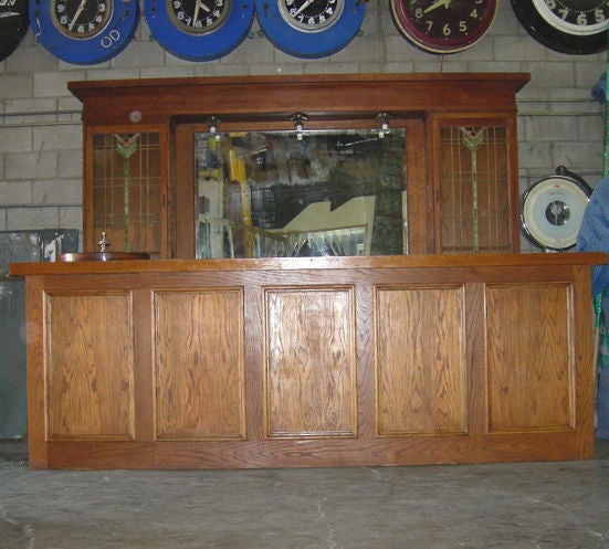 This 1915 to 1920's  Back Bar has original leaded glass windows, backbar mirror and one continuous white marble counter top. In addition a custom Front bar has been fitted with an antique Roulette Wheel and a hand painted Roulette layout.  Built of