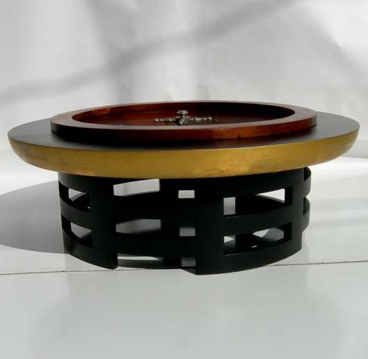 This iconic Kittinger coffee table, designed by Muller, was the base for our 1920's working casino roulette wheel. The top has been ebonized, and an opening created to house the wheel. The wheel is an early example, as it has 36 numbers and a green