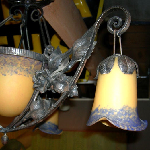A very finely crafted fixture with beautiful colored glass elements. The Art Nouveau theme is carried out in the nature forms of the plant - like metal and hanging tulip shades. The glass is lovely and free of chips and cracks. New wiring will be