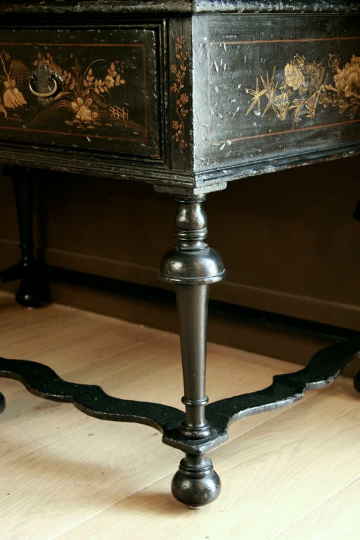 the molded frieze above two short and three long drawers <br />
each decorated in shades of gilt with birds, pavilions and flowers on a black ground <br />
the stand with a long drawer, raised on inverted trumpet-form legs joined by stretchers on