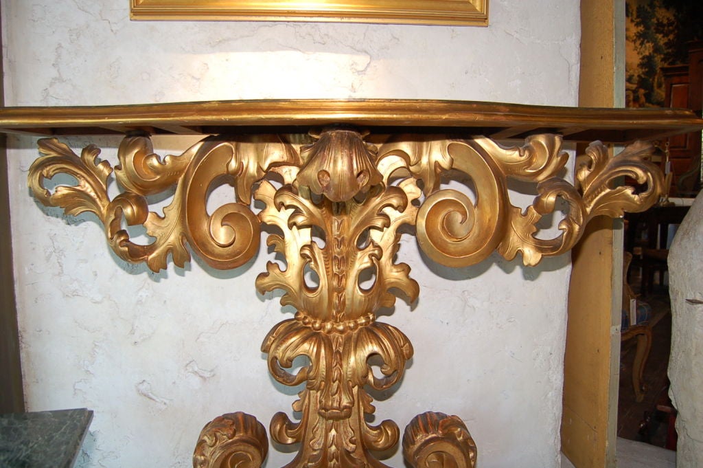 Early 1800s Italian gold giltwood console with faux marble top (top not original)
Measures: 51'' W x 15'' D x 35'' H.