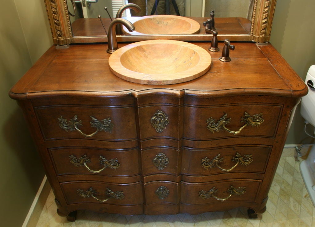 18th century French walnut bombe' commode with original hardware. Converted into vanity with stone sink and bronze hardware. Bottom drawer is functional.
Measures: 47'' W x 22'' D x 35.5'' H (without sink.)
(Also: chest of drawers, Bombay).