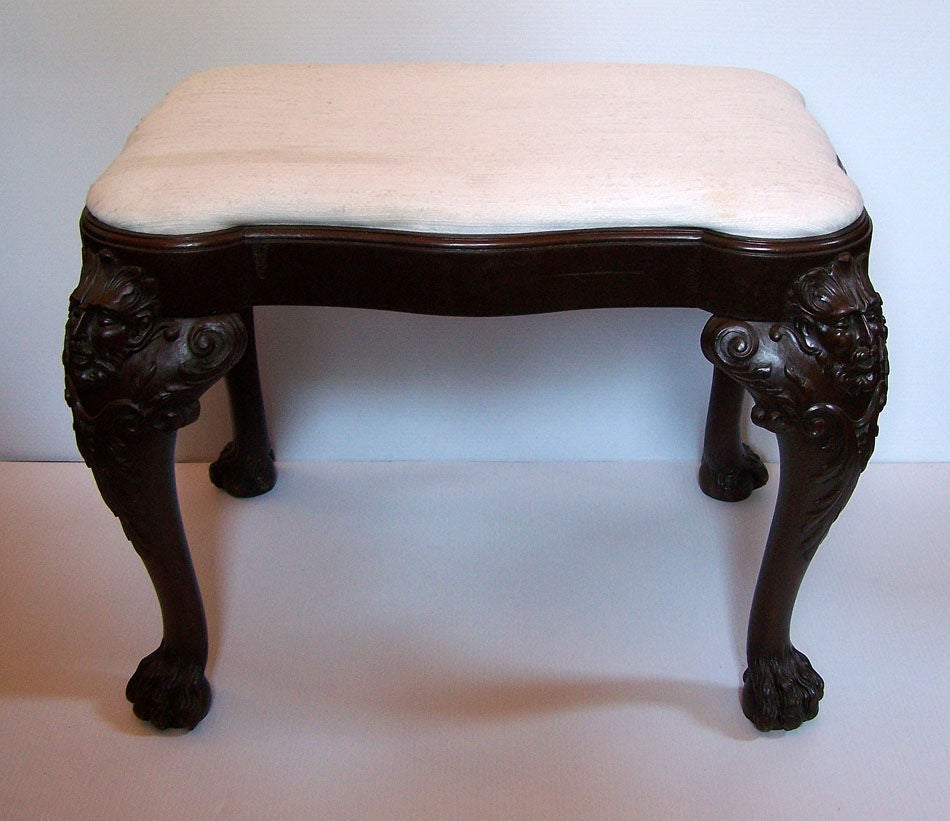 Mahogany bench or footstool with magnificent carved masks and hairy paws.